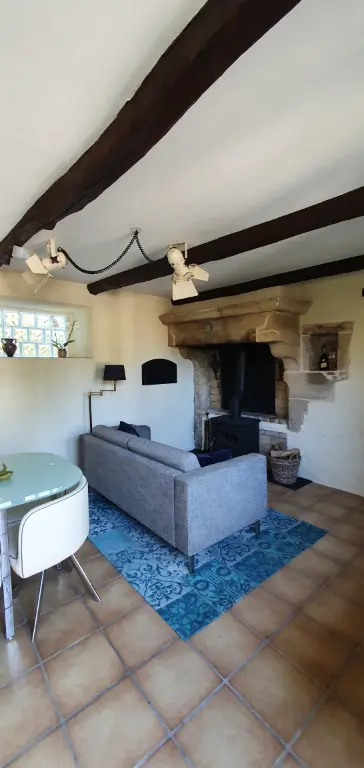 Huiskamer met bank en de oude schouw van Le Fier Paon.