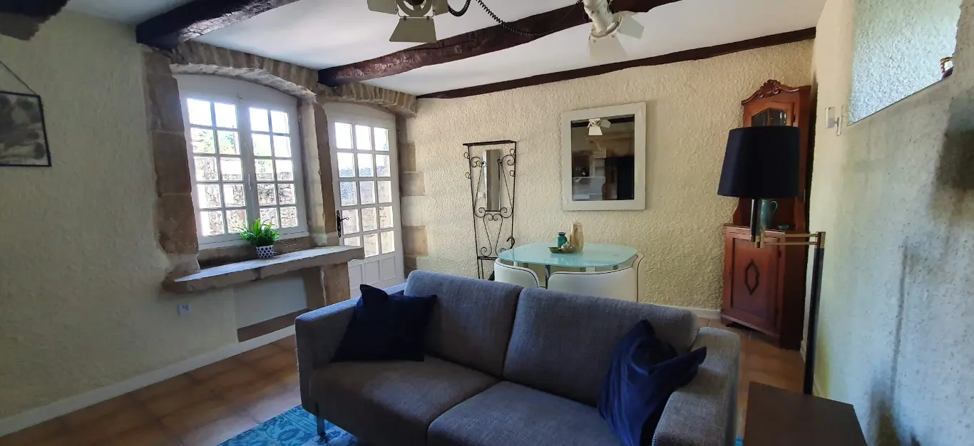 Sfeerfoto van huiskamer met bank, eettafel en schilderij een stilleven.