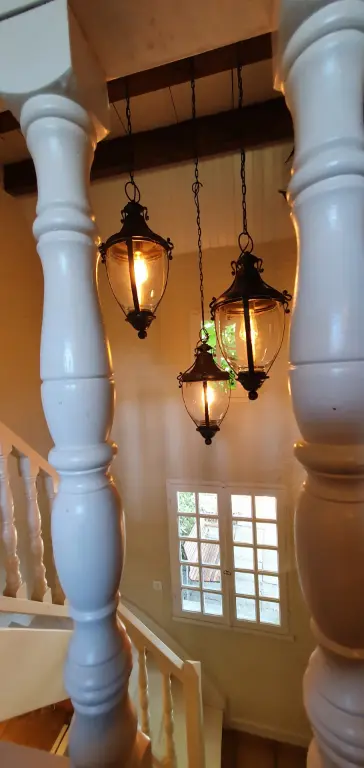 Onze schitterende antieke lampen die in de gite/vakantiehuis hangen, hier te zien tussen de sierlijke trapspijlen.
